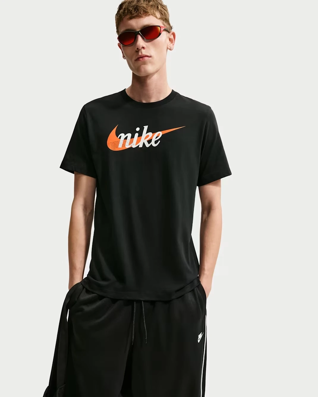 Nike Sportswear black T-shirt with orange Nike logo.