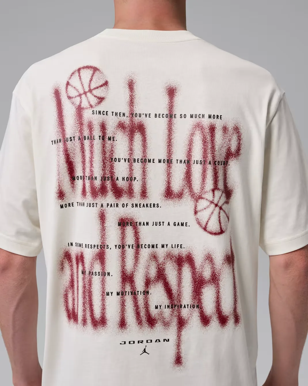 Close-up of the back graphic on the Jordan Brooklyn Love Letter T-Shirt in Soft Pearl featuring oversized Team Red artwork and inspirational text.