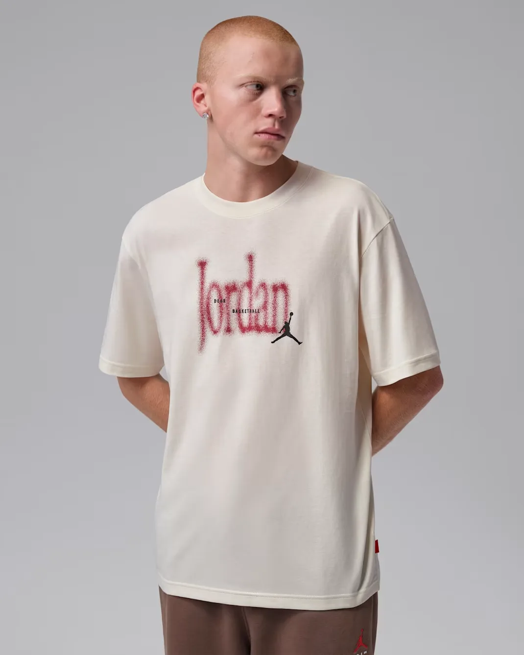 Front view of the Jordan Brooklyn Love Letter T-Shirt in Soft Pearl with Team Red Jordan graphic and black Jumpman logo.