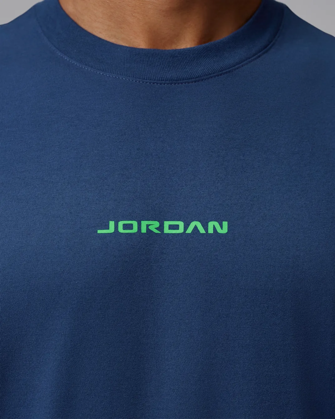 Close-up of the green Jordan logo on the front of the Jordan AJ13 Graphic T-Shirt in French Blue.