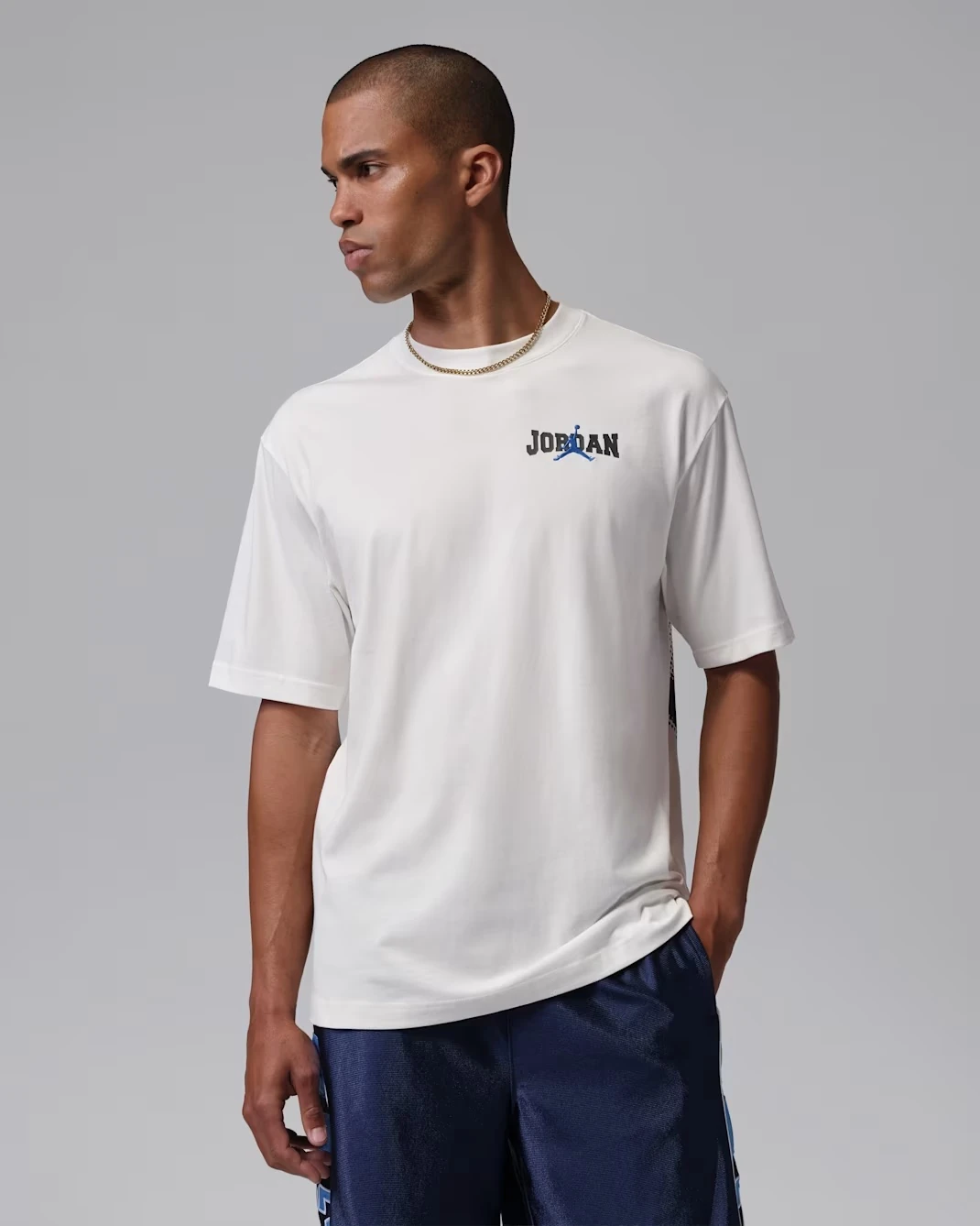 Front angled view of the Jordan Brooklyn 85 T-Shirt in Sail and Game Royal, matching the Air Jordan 13 Flint (2026).