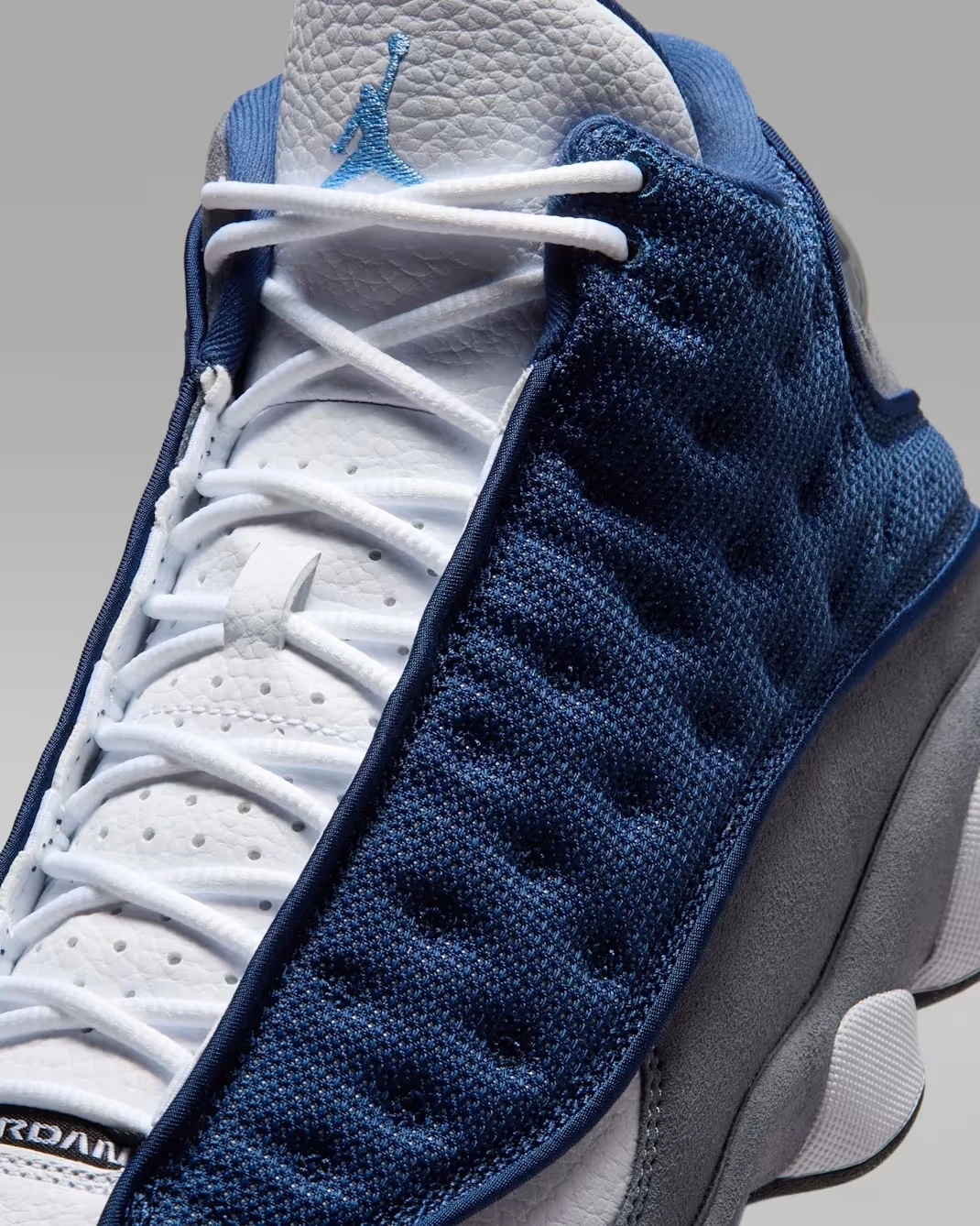 Close-up of the tongue and mesh on the Air Jordan 13 Flint (2026) in Navy, University Blue, Flint Grey, and White.
