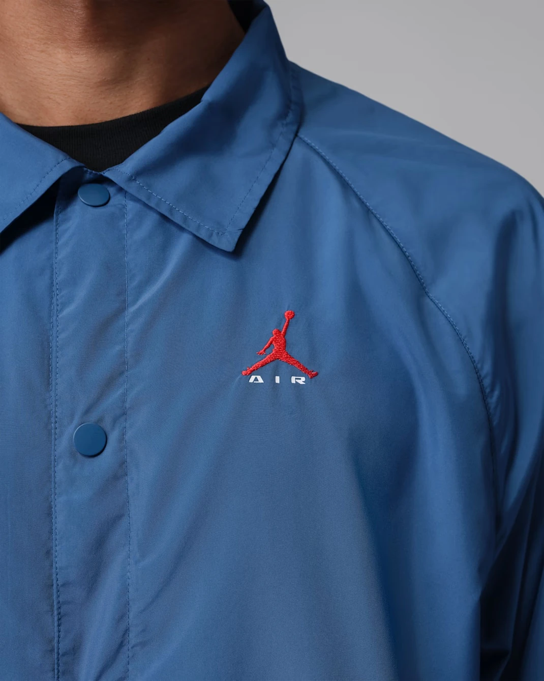 Close-up of the embroidered white Jumpman logo on the chest of the Jordan Brooklyn Coaches Jacket in True Blue.
