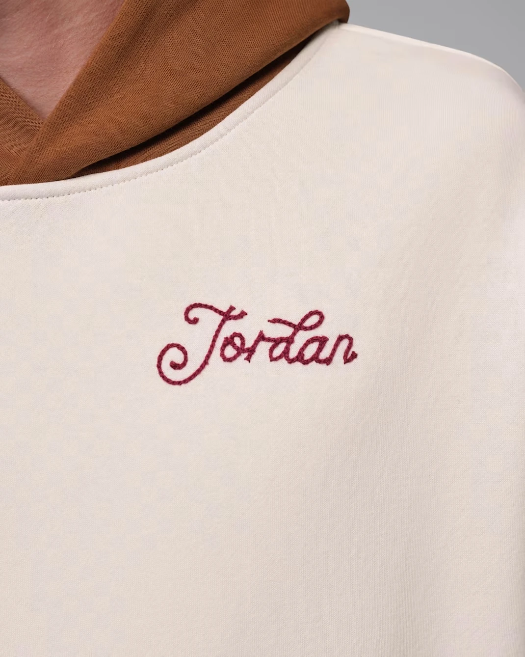 Close-up of the embroidered Jordan script logo on the Soft Pearl Jordan Brooklyn Fleece Hoodie.
