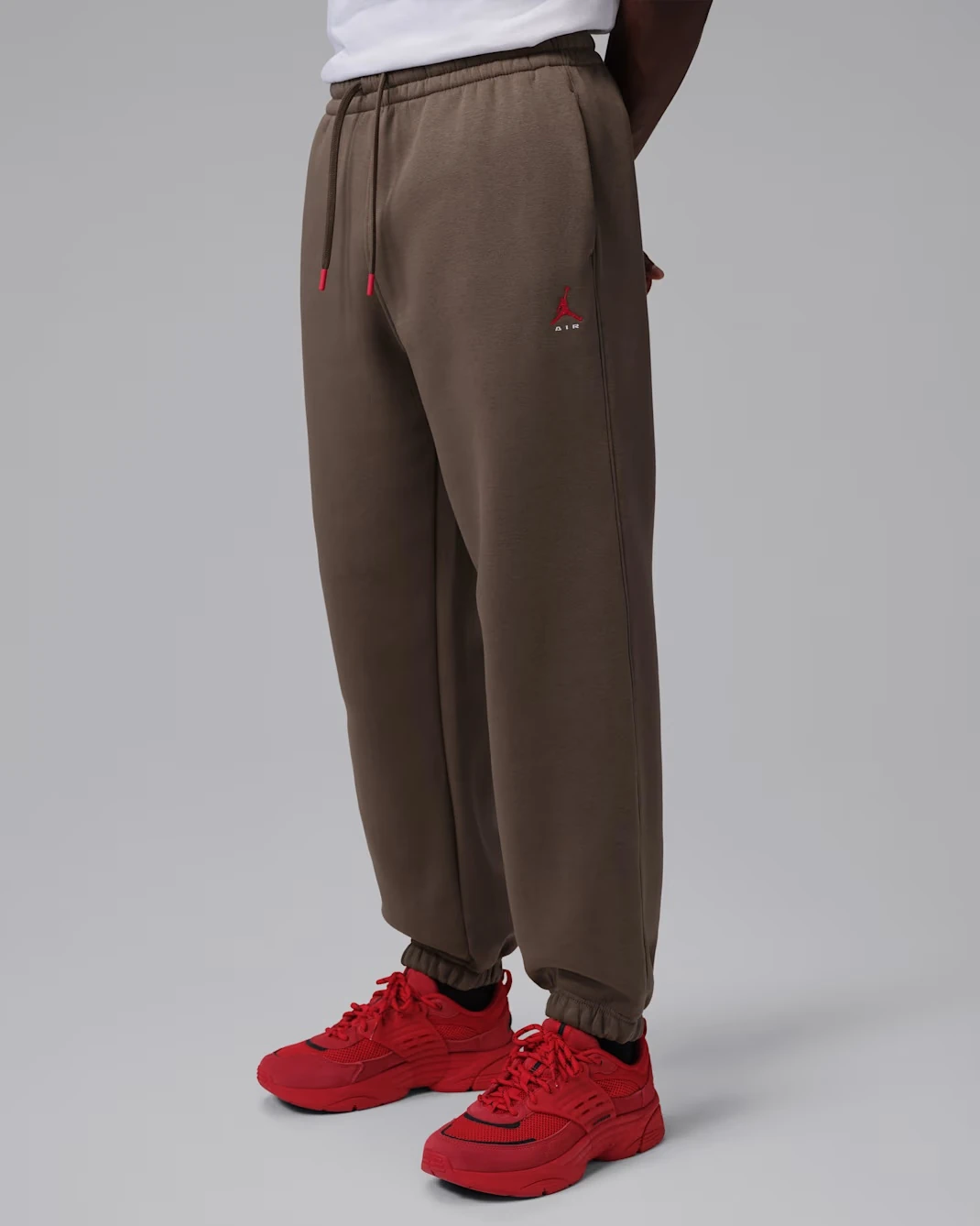 Jordan Brooklyn men's fleece pants in Palomino paired with the Air Jordan 1 Mid Black/Palomino sneakers.