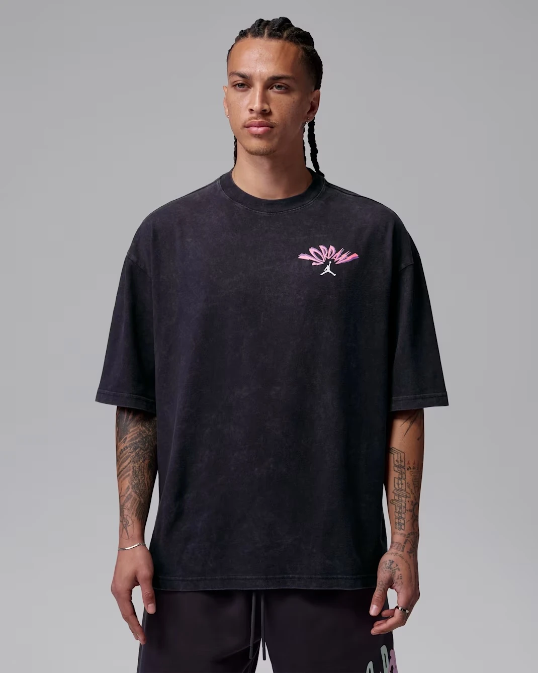 Front view of the Jordan Flight T-Shirt in Black with pink Jordan logo graphic.