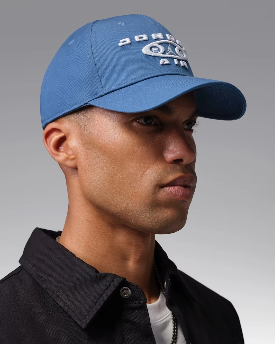 Side profile of the Jordan Rise Structured Snapback Cap in True Blue and White worn by a model.