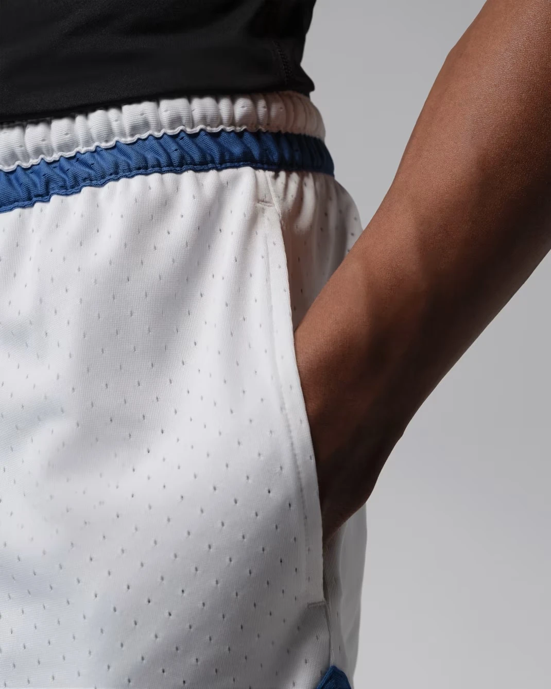 Close-up of the side pocket and breathable mesh fabric on the Jordan Sport Mesh Diamond Shorts in White and True Blue.