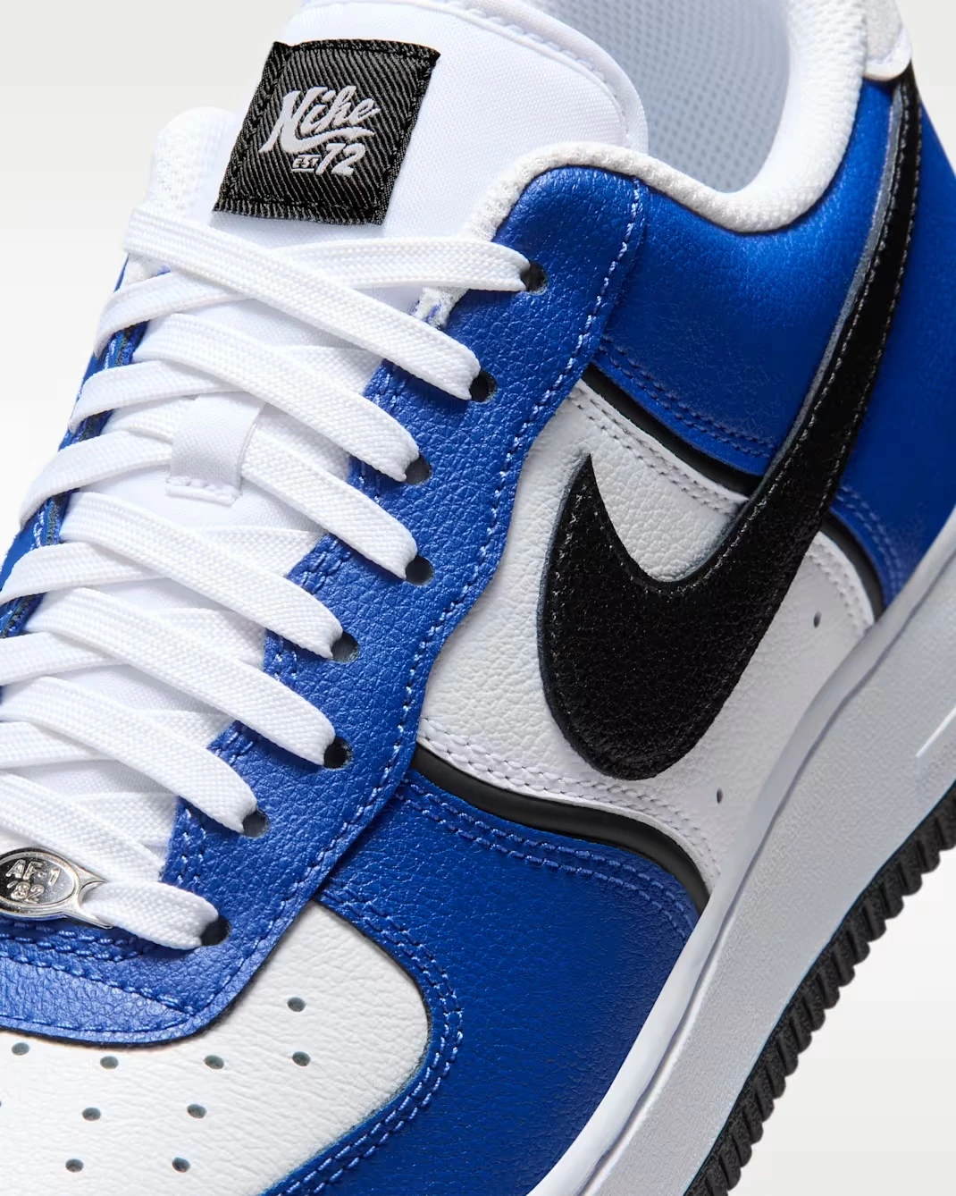 Close-up of the Nike Swoosh and leather upper on the Nike Air Force 1 '07 LV8 in Old Royal, White, Metallic Silver and Black.
