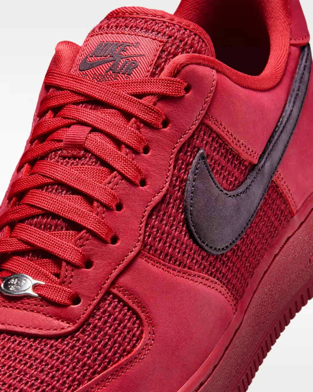 Close-up of the Nike Air Force 1 Low "Tough Red" featuring the laces, tongue and Swoosh.