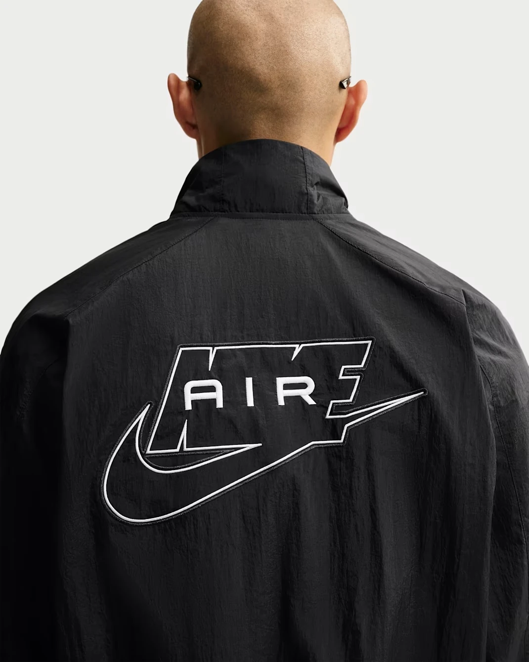 Back view of the Nike Air Men's Woven Track Jacket in black with white piping and oversized Nike Air logo.