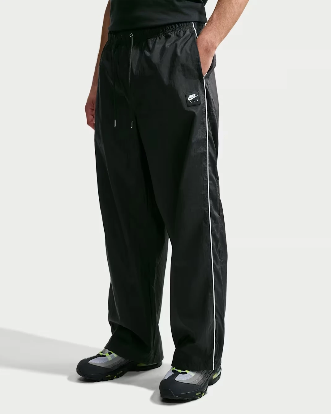 Nike Air Men's Woven Track Pants in black with white side piping.