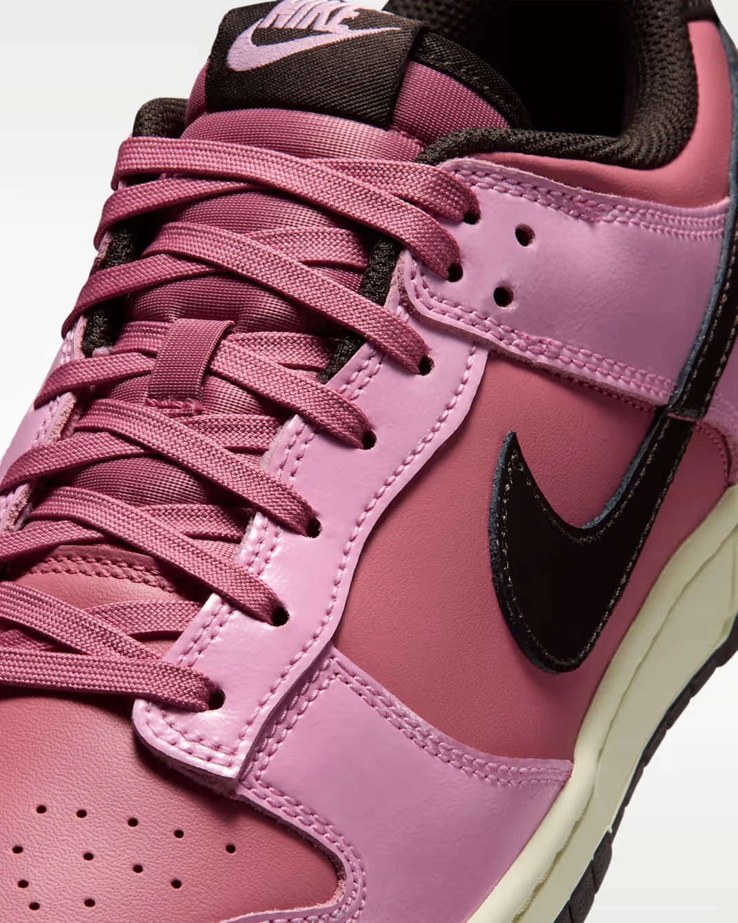 Close-up of the Nike Dunk Low "Pink Donut" showing the laces, leather upper and Velvet Brown Swoosh.