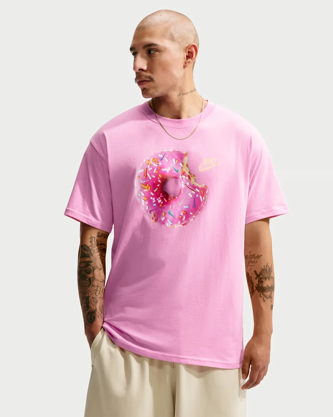 Front view of the Nike Sportswear "Donut" Men's T-Shirt in Pink Rise featuring a pink donut graphic to match the Nike Dunk Low "Pink Donut."
