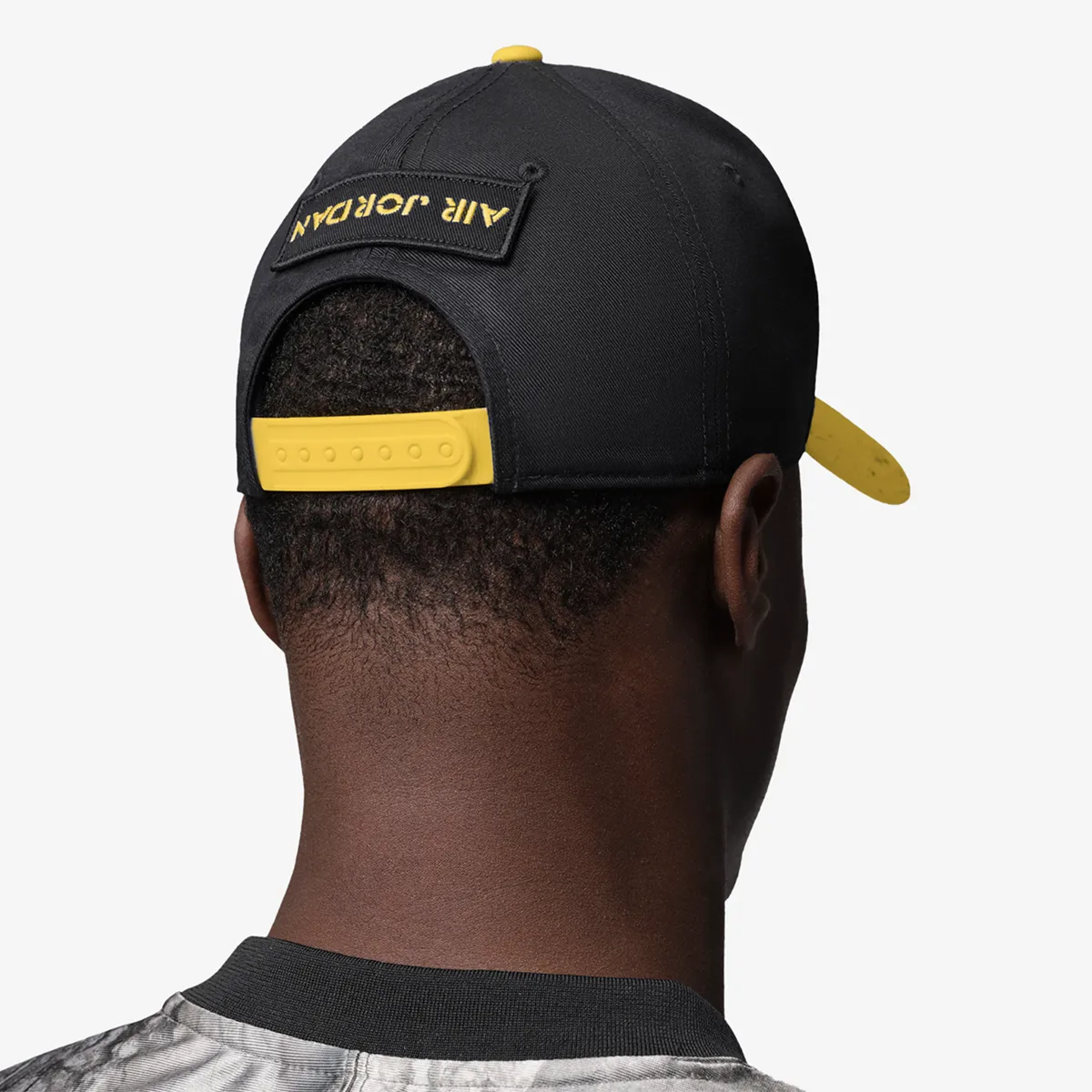 Back view of Jordan Rise Cap snapback hat in black and Tour Yellow with yellow adjustable closure