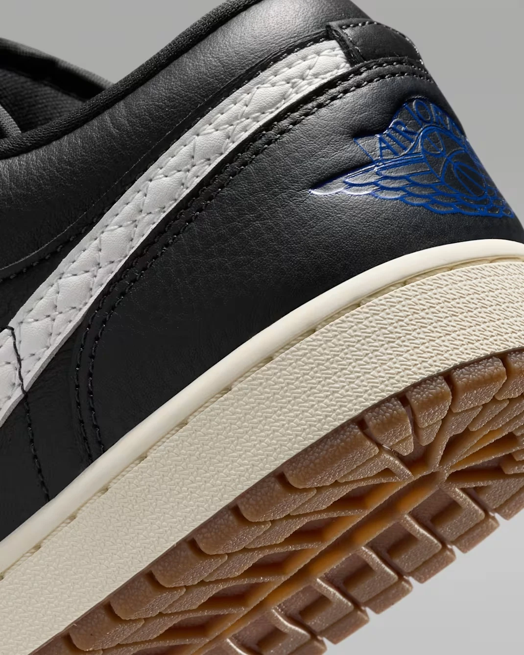 Close-up of the heel, quilted Sail Swoosh and Game Royal Wings logo on the Air Jordan 1 Low SE Quilted "Off Noir."