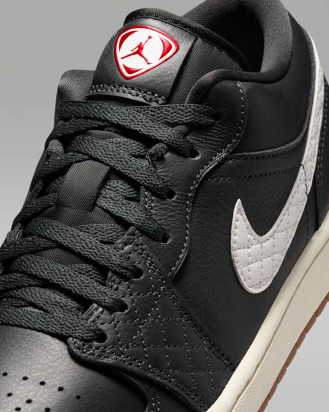 Close-up of the quilted leather overlays and Sail Swoosh on the Air Jordan 1 Low SE Quilted "Off Noir."