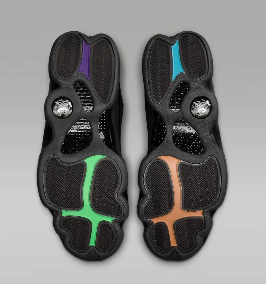 Bottom view of both Air Jordan 13 Retro Wings sneakers displaying multicolor outsole accents.