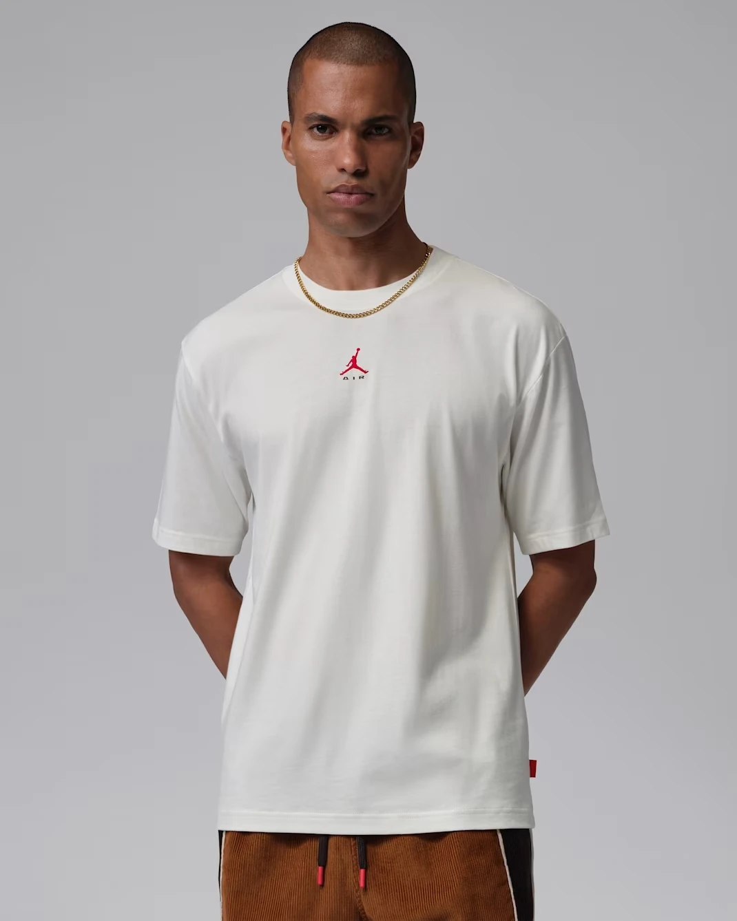 Front view of the Jordan Brooklyn Men's T-Shirt in Sail with University Red Jumpman logo.