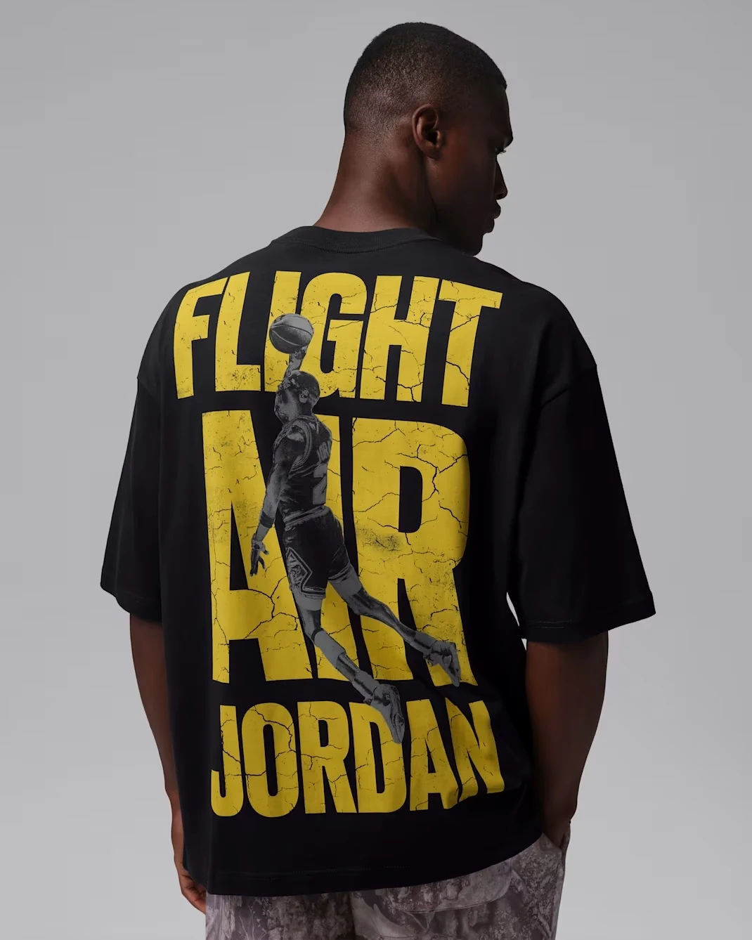 Back of black Jordan Flight T-shirt with large Tour Yellow Flight Air Jordan graphic.