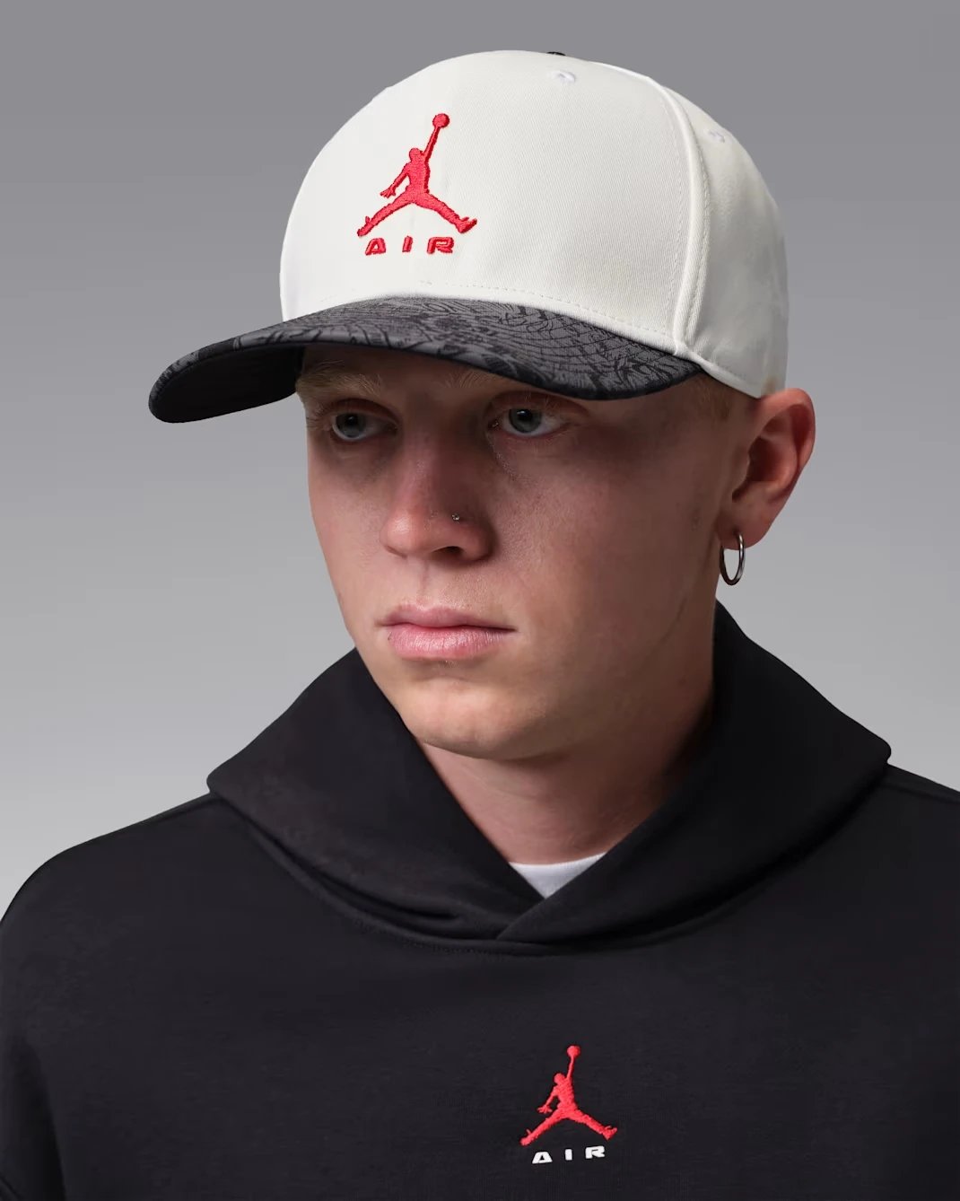 Front view of the Jordan Pro Structured Cap in Sail with a black patterned visor and University Red Jumpman logo.