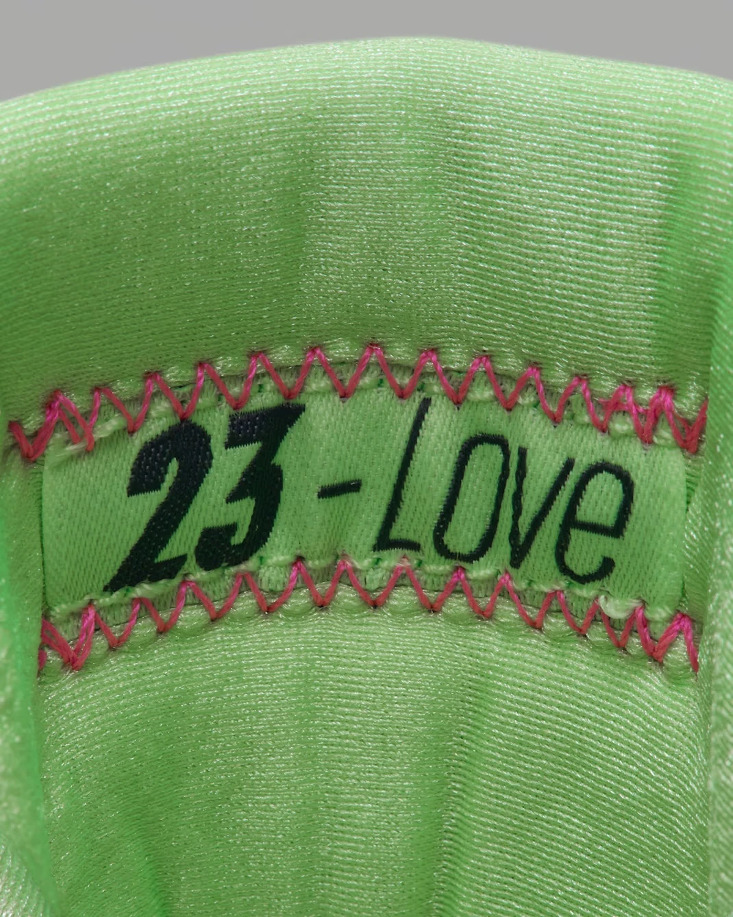 Air Jordan 7 Tennis Day lime green tongue with pink stitching and 23 Love detail.