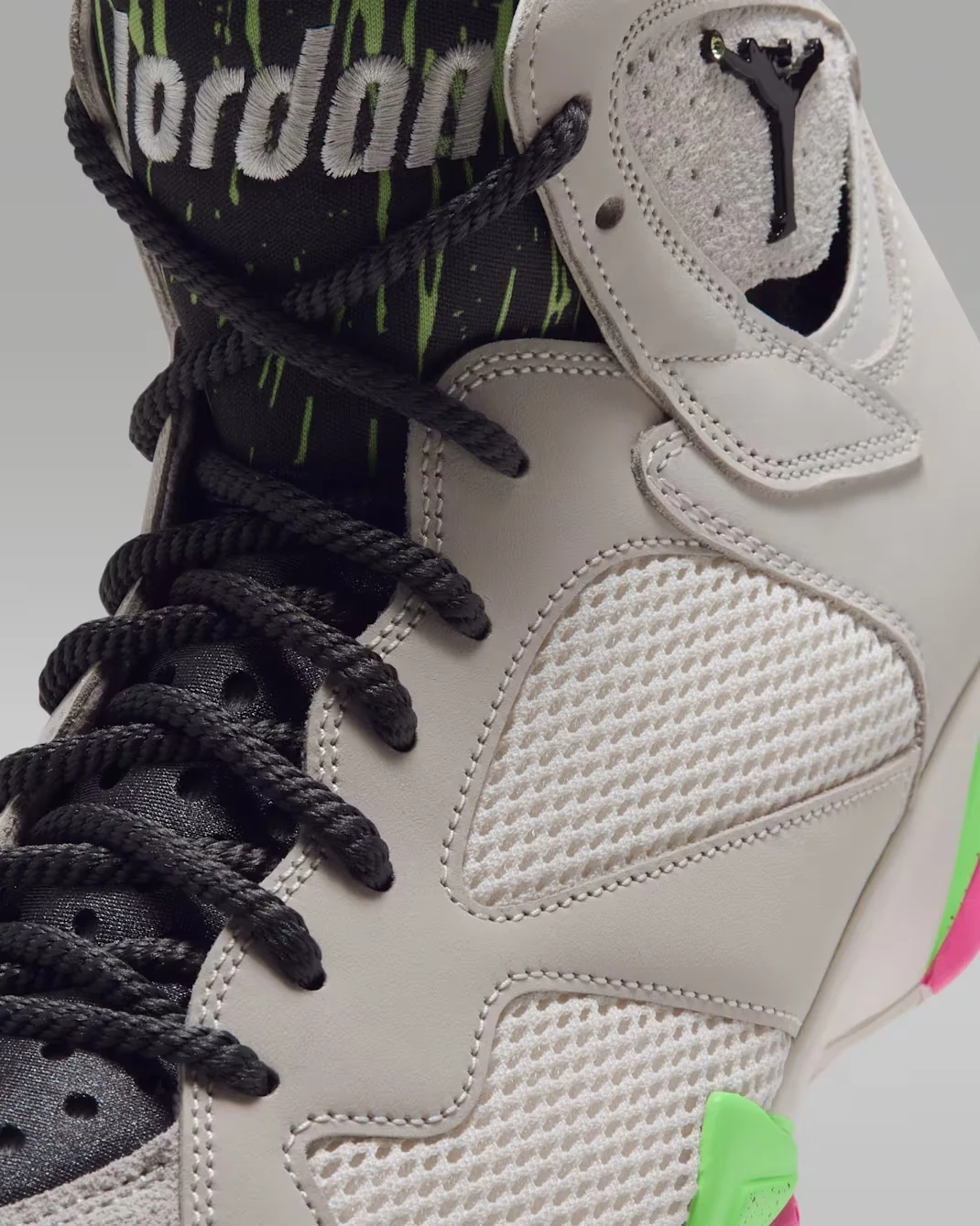 Close-up of the Air Jordan 7 Tennis Day Phantom upper with black laces, lime tongue graphics and Jumpman logo.