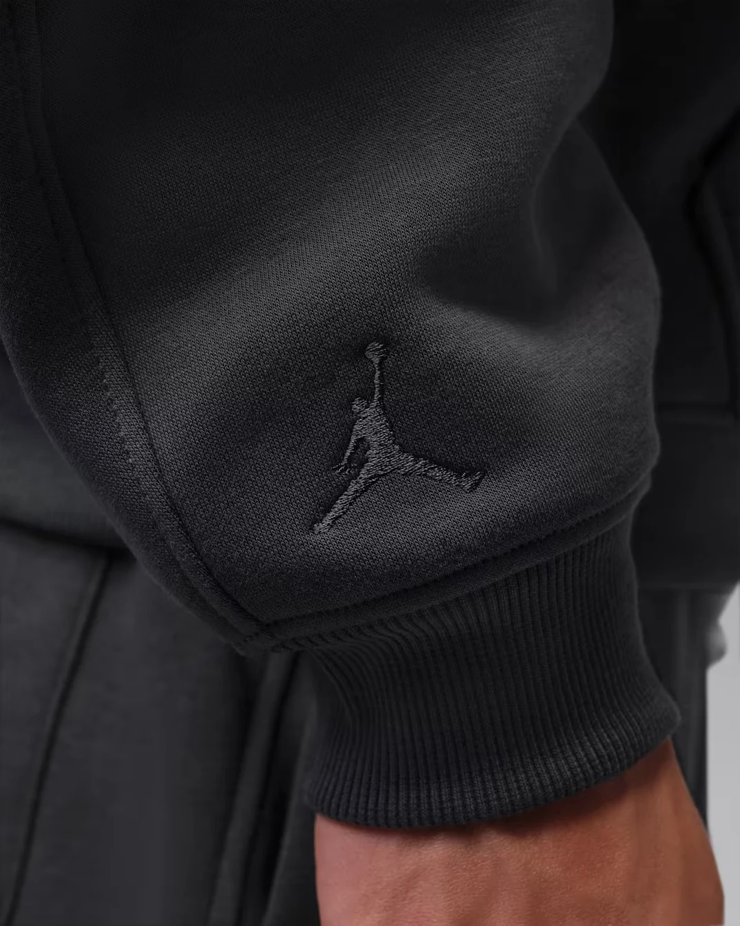 Tonal Jumpman embroidery on the sleeve of the Anthracite Jordan Brooklyn Fleece 23-Love hoodie.