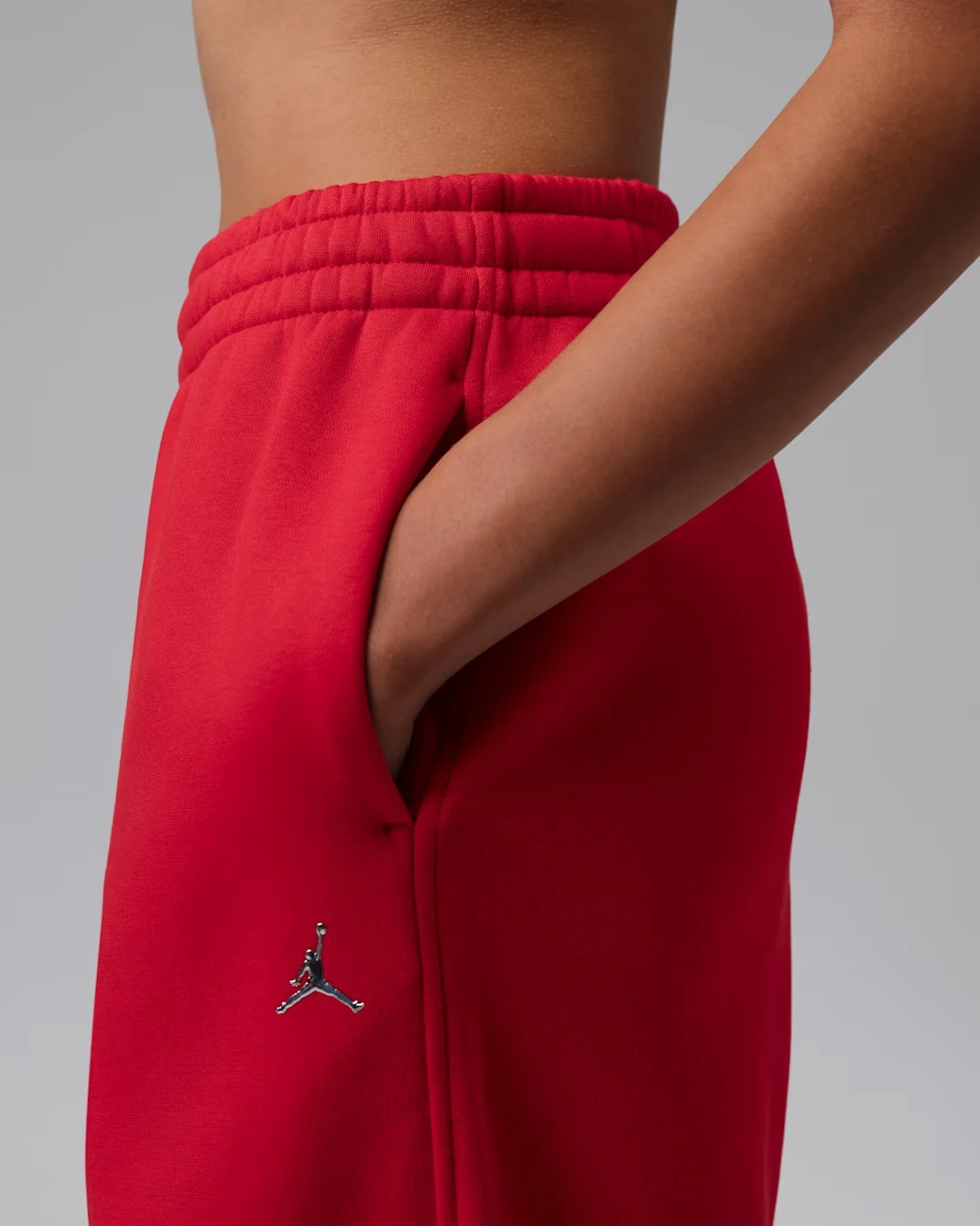 Close-up of Jordan Brooklyn women’s jogger pants in Gym Red with Metallic Silver Jumpman