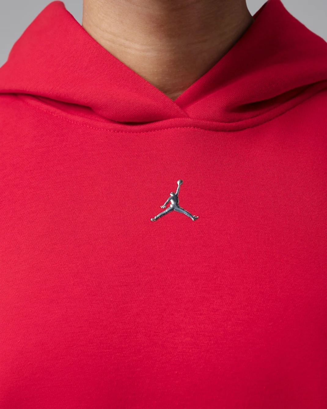 Close-up of Jordan Brooklyn women’s pullover hoodie in Gym Red with Metallic Silver Jumpman