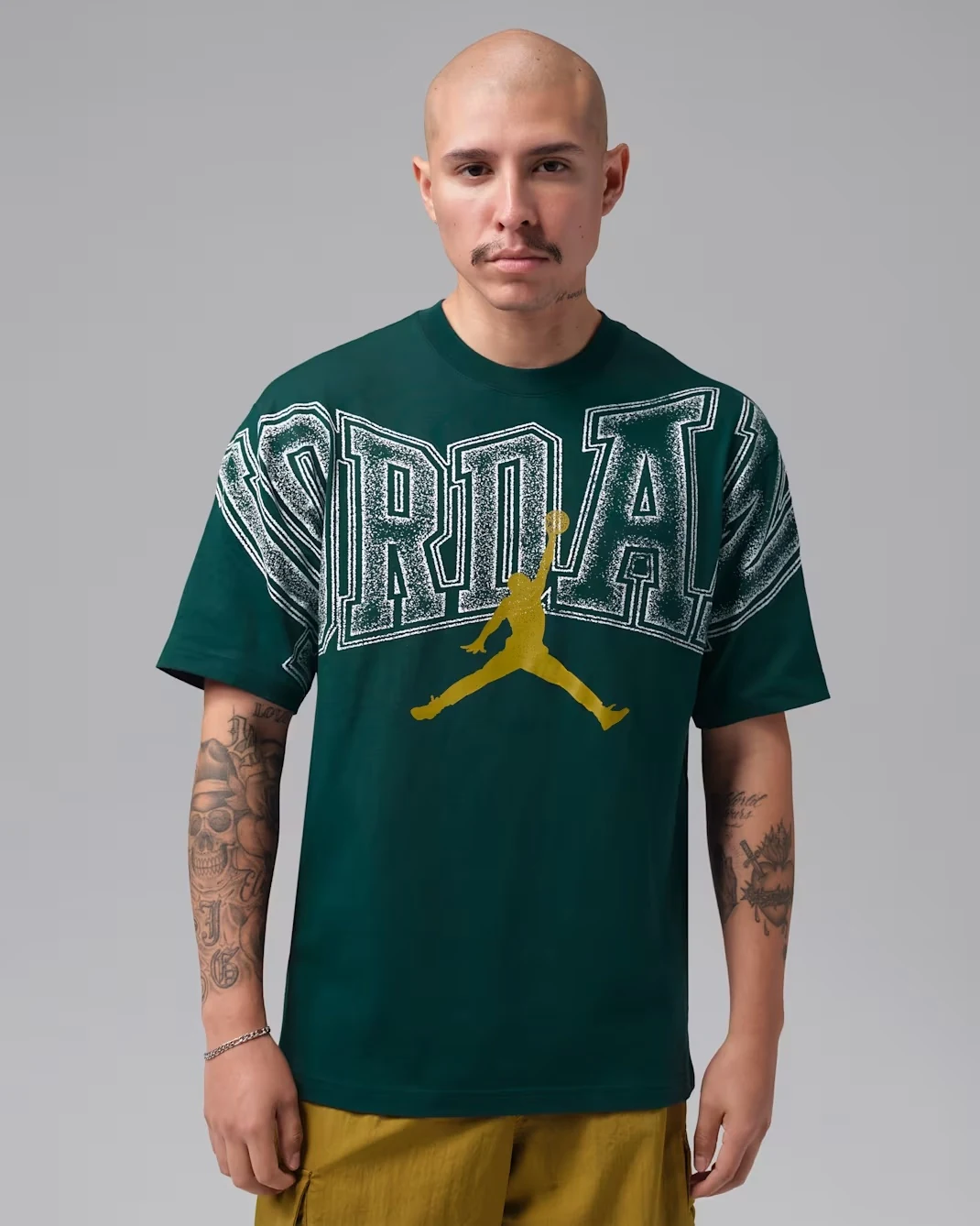 Jordan men's graphic T-shirt in Midnight Spruce with oversized white Jordan lettering and gold Jumpman logo.