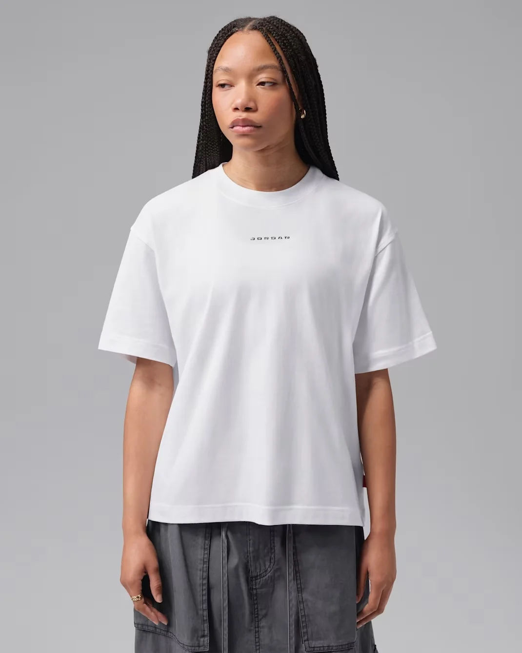 Woman wearing a white Jordan Flight graphic T-shirt with black detailing.