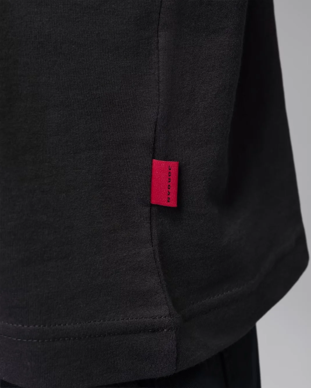 Red Jordan label detail on the Off Noir Jordan Women’s Graphic Girlfriend T-Shirt.