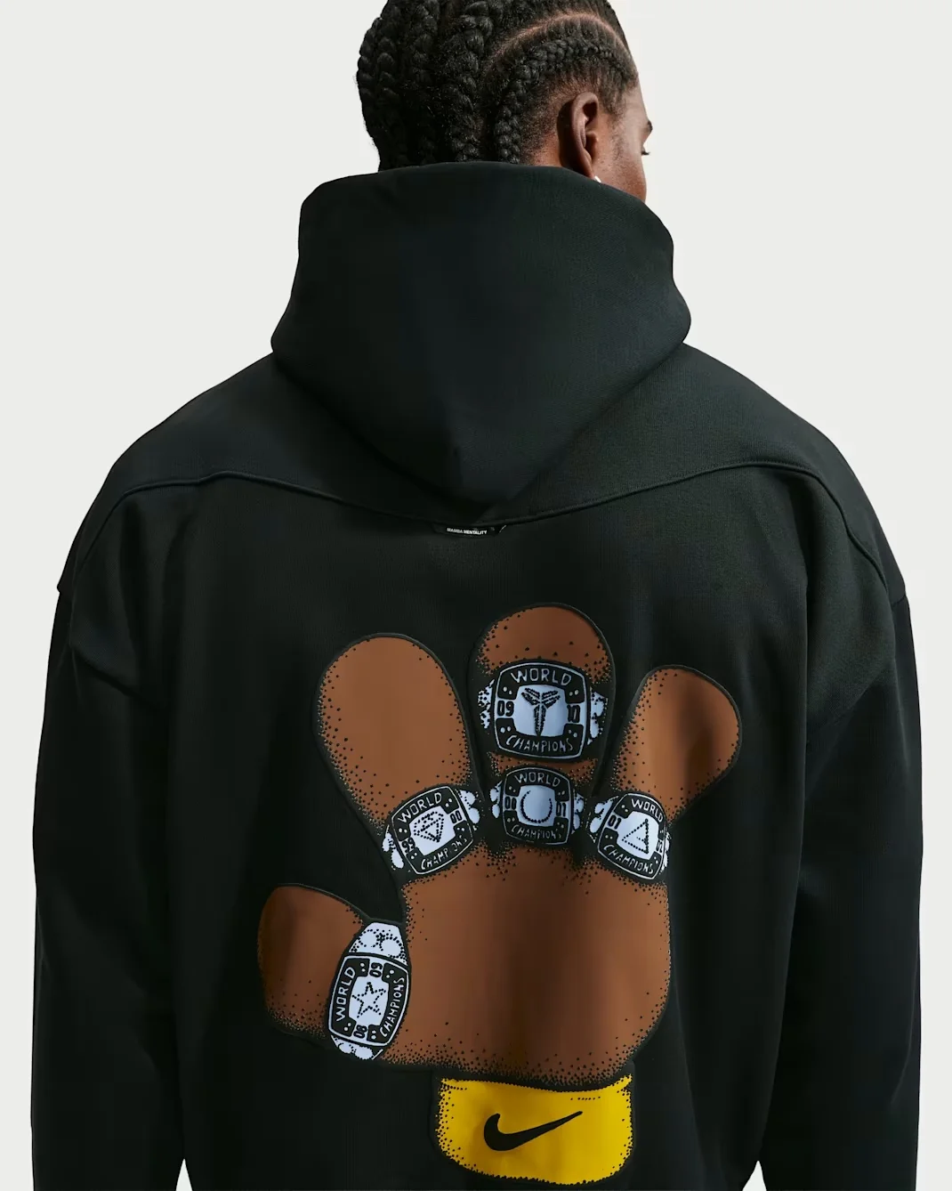 Back of black Nike Kobe hoodie with brown hand and white championship ring graphics.