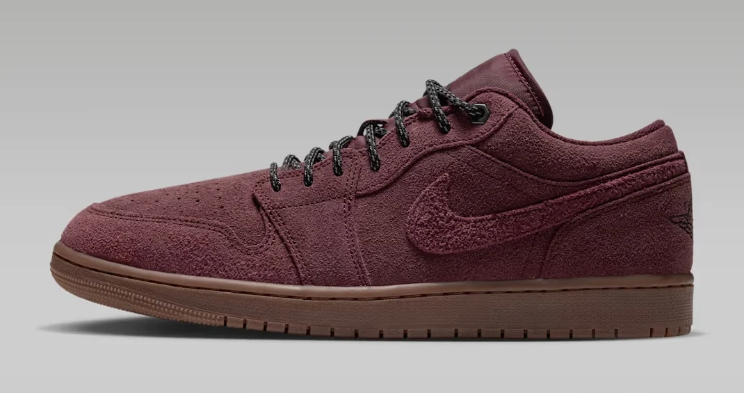 Air Jordan 1 Low SE Dark Team Red sneaker featuring a burgundy suede upper, matching textured Nike Swoosh, black laces and brown rubber outsole, shown from the side.