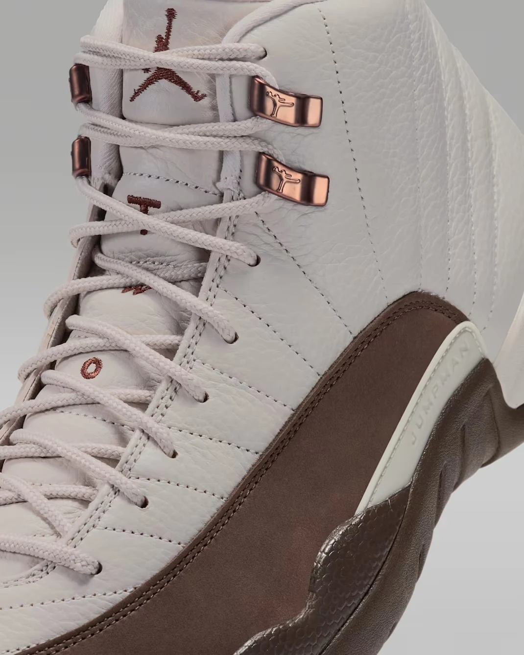 Close-up of Air Jordan 12 Fireside Light Orewood Brown leather, matching laces, metallic lace hooks and Cacao Wow mudguard