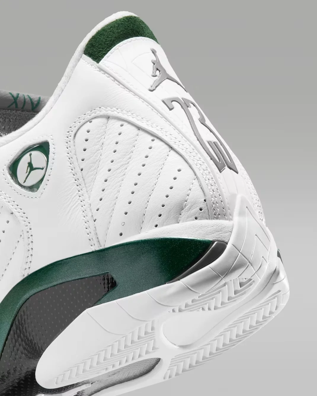 Close-up of the Air Jordan 14 Retro Forest Green heel showing grey Jumpman and number 23 branding, white leather and green accents.