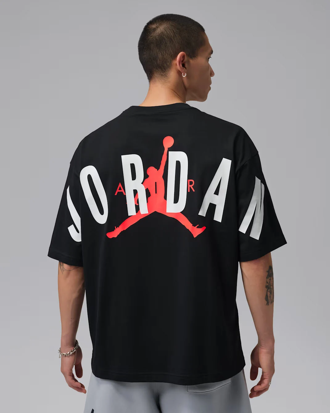 Back view of black Jordan Back Stretch Oversized T-Shirt with oversized white Jordan lettering and Infrared Jumpman graphic, matching the Air Jordan 6 White Infrared.