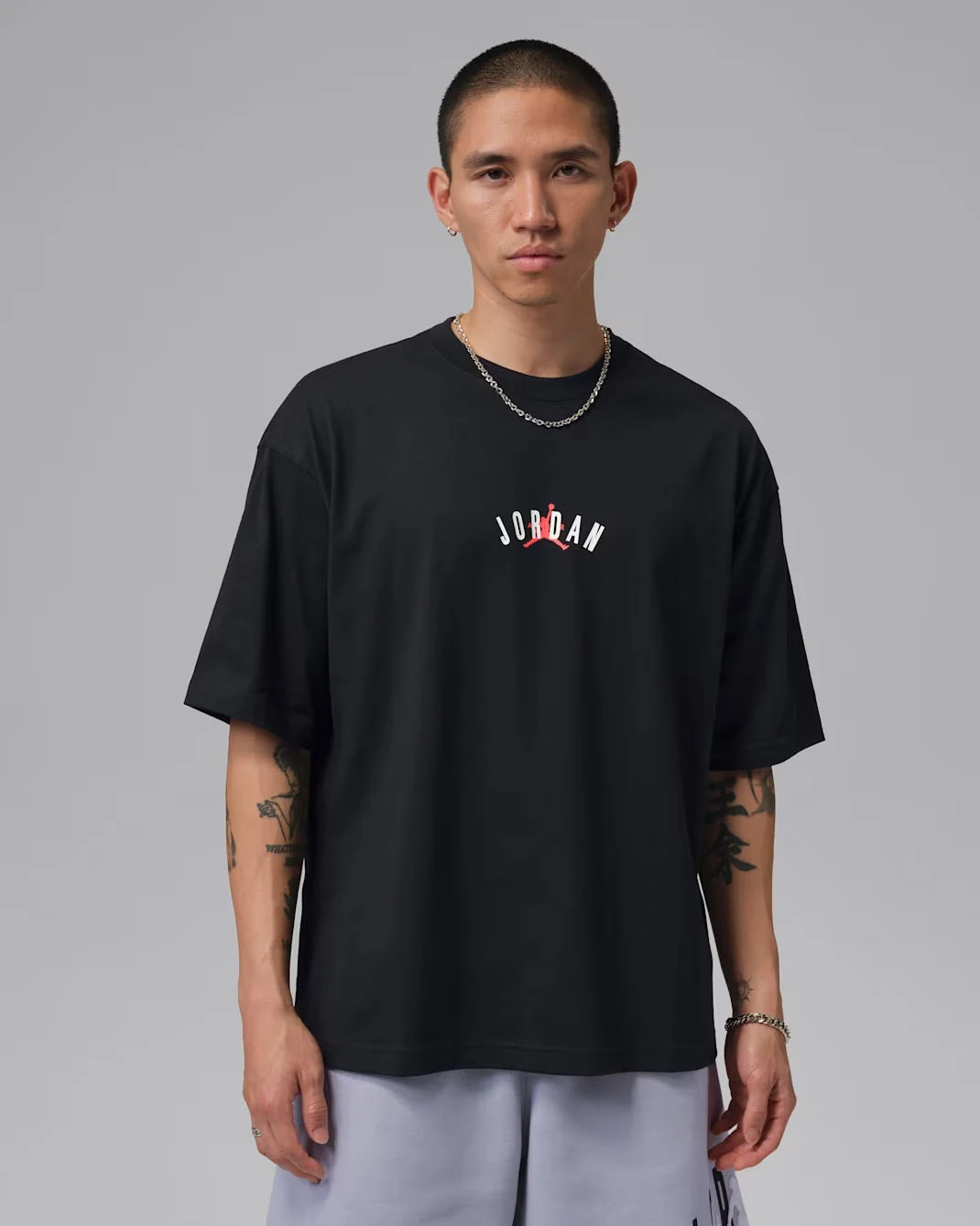 Front view of black Jordan Back Stretch Oversized T-Shirt with small white Jordan lettering and Infrared Jumpman chest graphic, styled to match the Air Jordan 6 White Infrared.