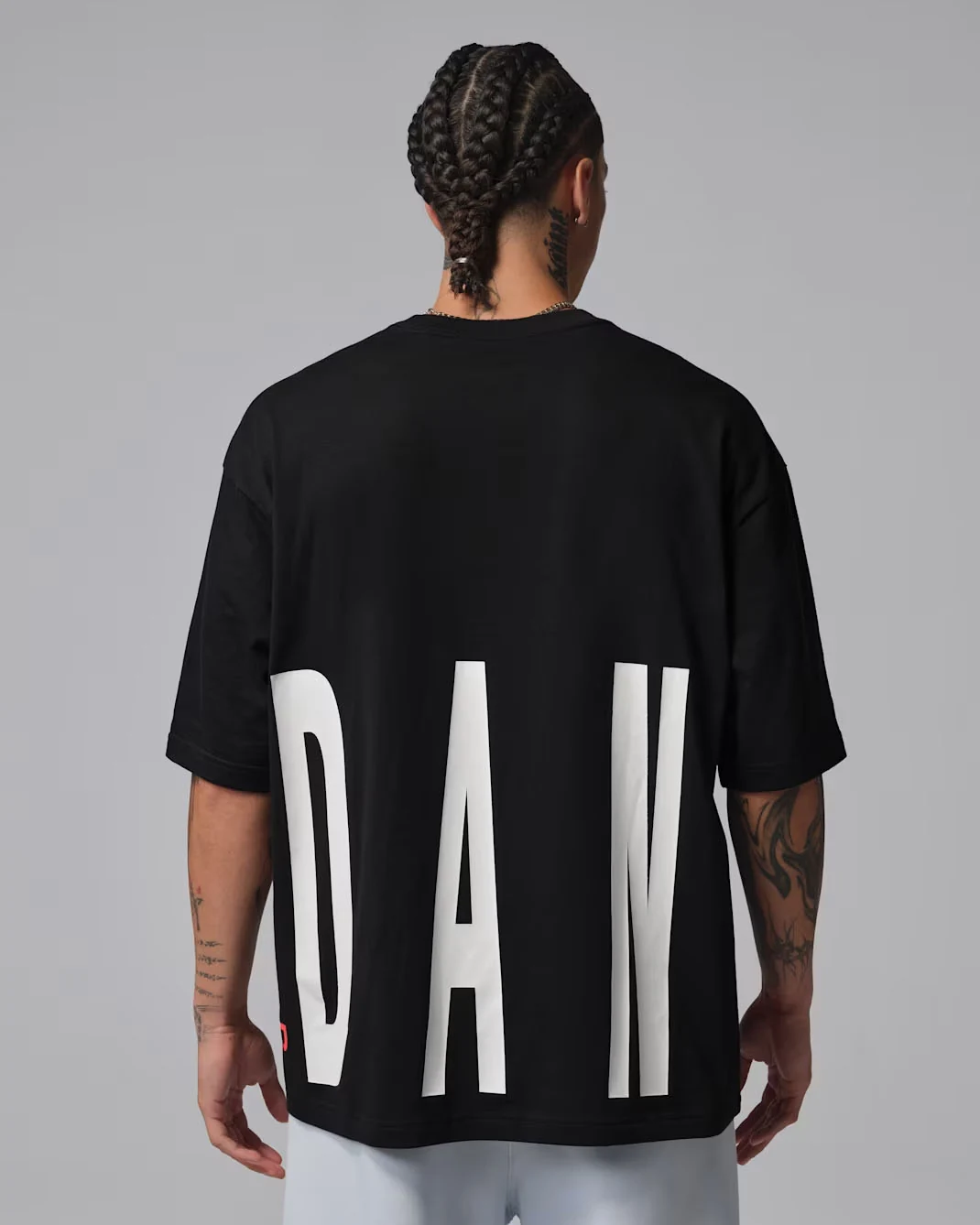 Back view of black Jordan Torso Stretch Oversized T-Shirt featuring oversized white Jordan lettering across the lower back, matching the Air Jordan 6 White Infrared.