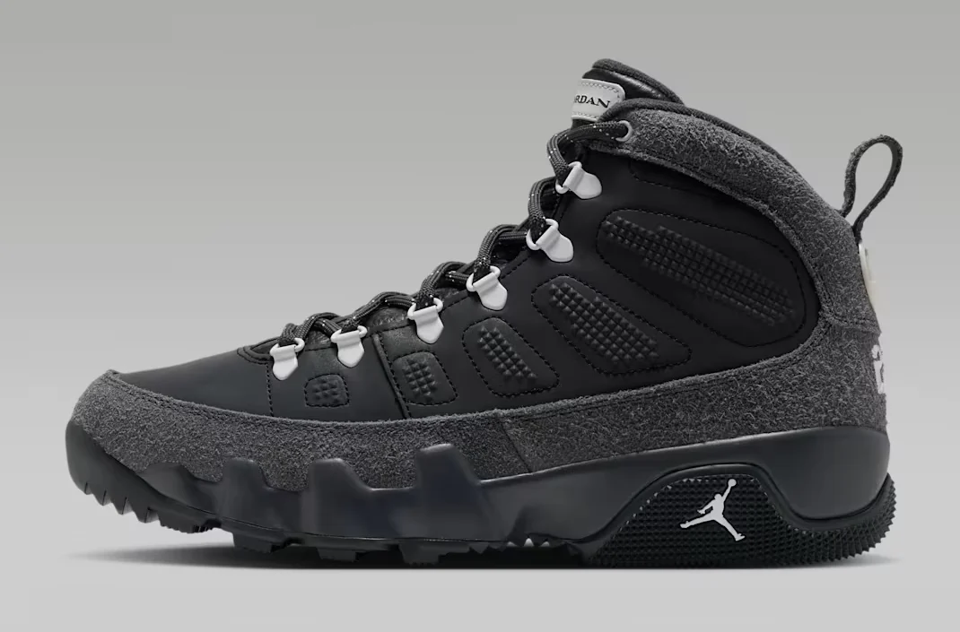 Air Jordan 9 Boot Anthracite Reflective featuring a black upper, textured dark grey suede overlays, white lace eyelets and rugged black outsole, shown from the side.
