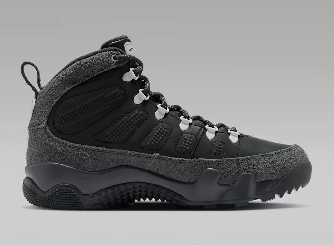 Medial side view of the Air Jordan 9 Retro Boot Anthracite Reflective with black panels, grey textured overlays and white lace hooks.