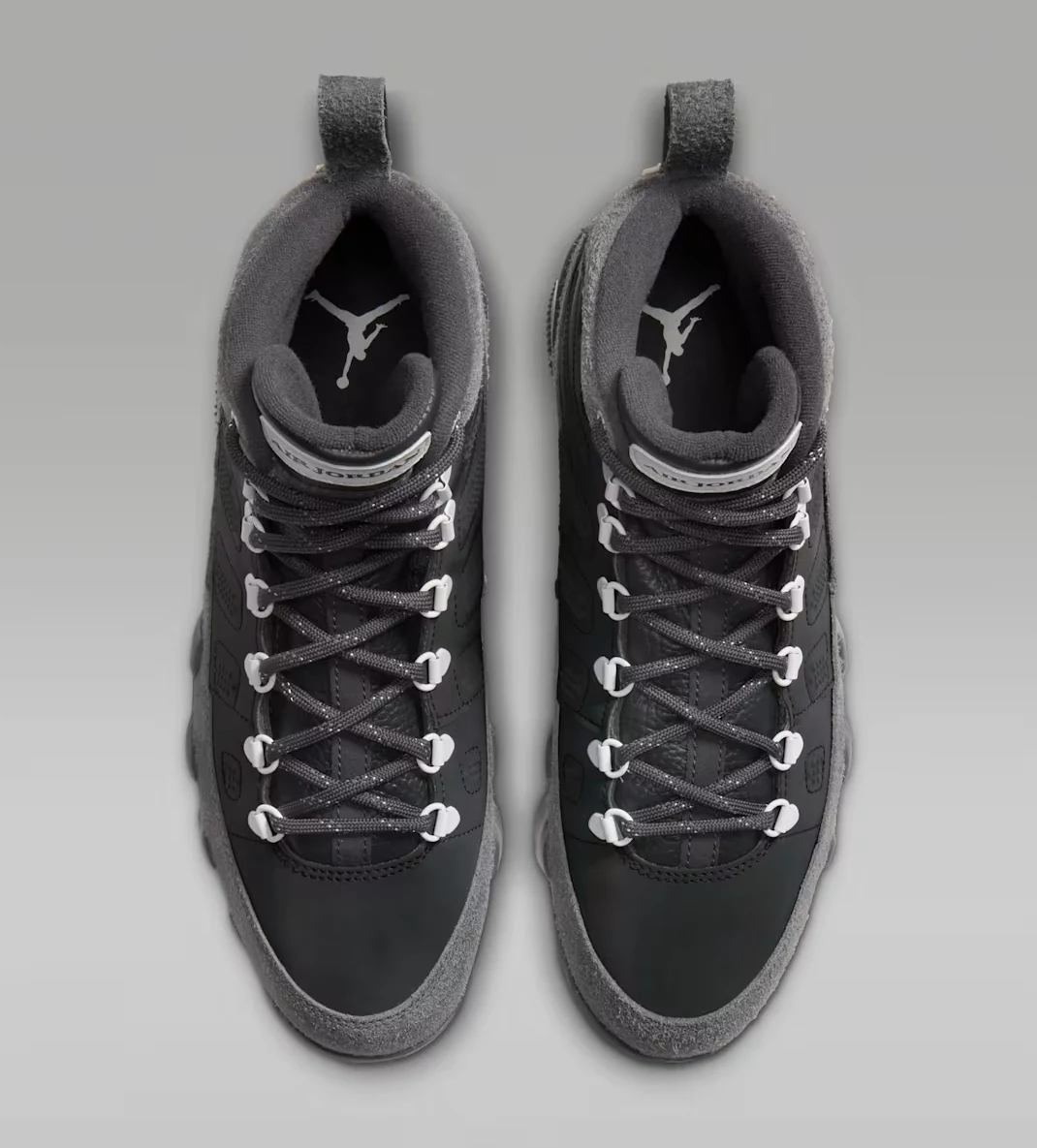 Top view of the Air Jordan 9 Retro Boot Anthracite Reflective pair featuring dark laces, white lace hooks and padded collars.