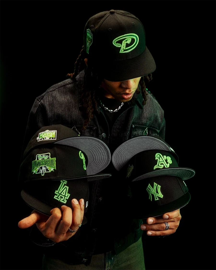 Model displaying New Era Neon Shadow 59FIFTY fitted hats in black with neon green embroidered MLB team logos.