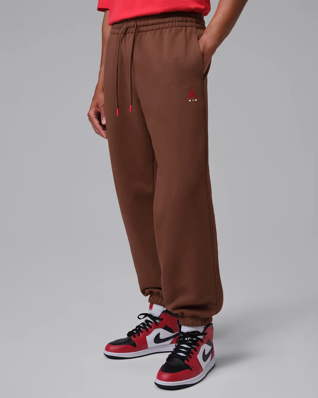 Model wearing Fauna Brown Jordan Brooklyn fleece pants with red Jumpman logo