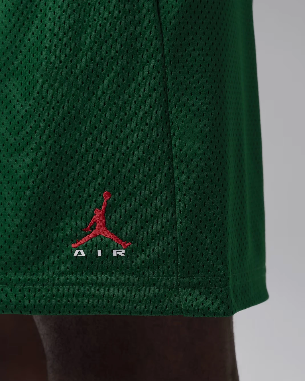 Close-up of Jordan Brooklyn men's Gorge Green mesh shorts showing University Red Jumpman embroidery.