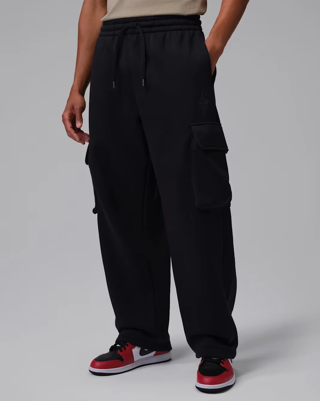 Front view of the Jordan Brooklyn oversized fleece cargo pants in Black and Dark Smoke Grey.