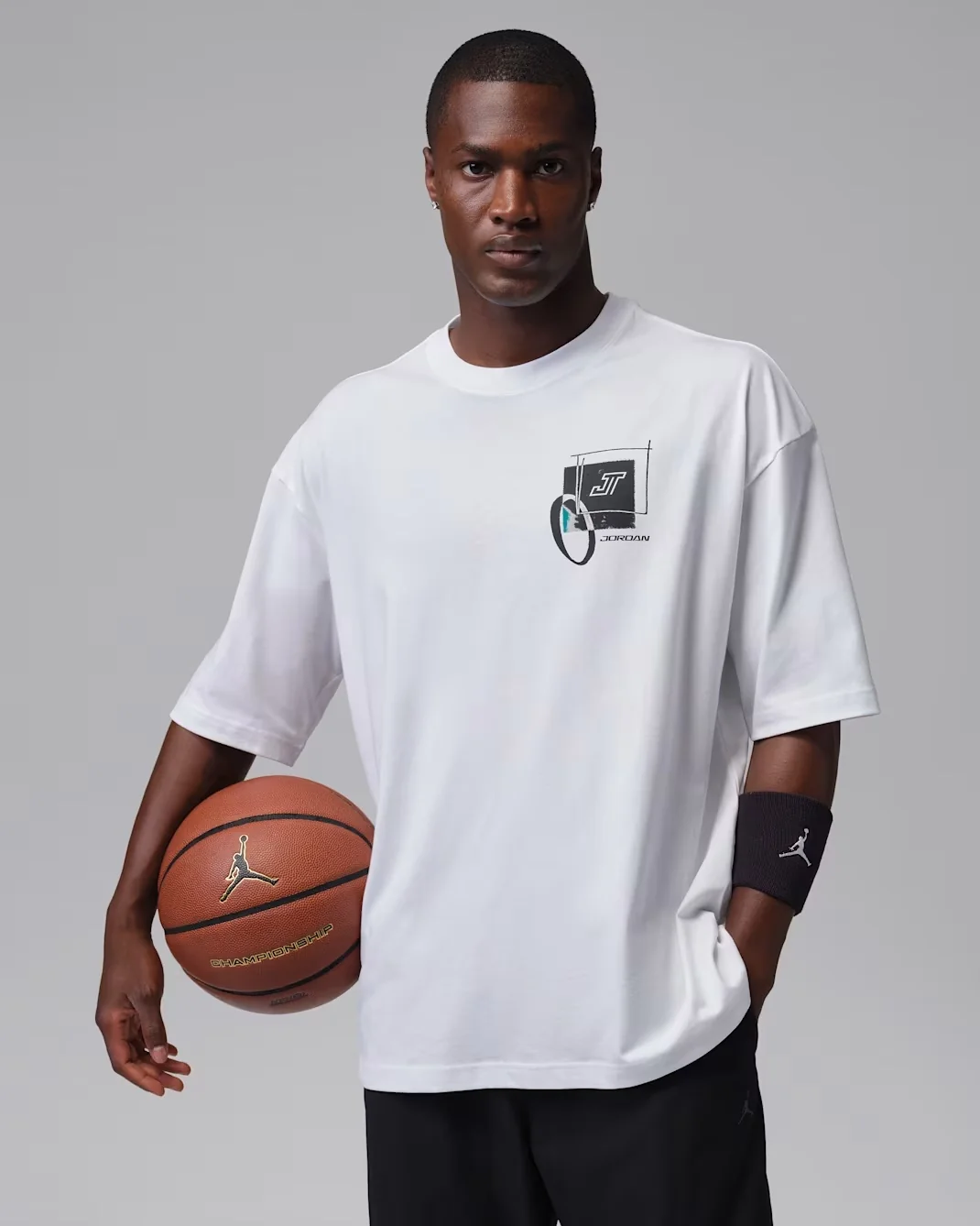 White Jordan Tatum Sport Dri-FIT Basketball T-Shirt featuring a small JT graphic on the front to match the Jordan Tatum 5 Sunrise sneakers.