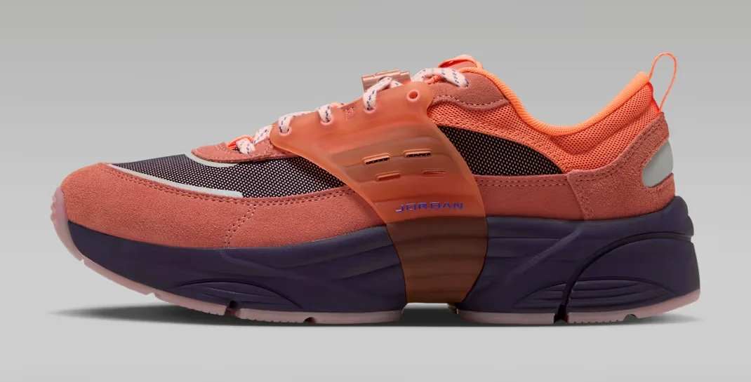 Jordan Trunner O/S Space Jam Planet sneaker featuring a coral-orange suede upper, translucent orange support cage, dark purple midsole and contrasting mesh panels, shown from the side.