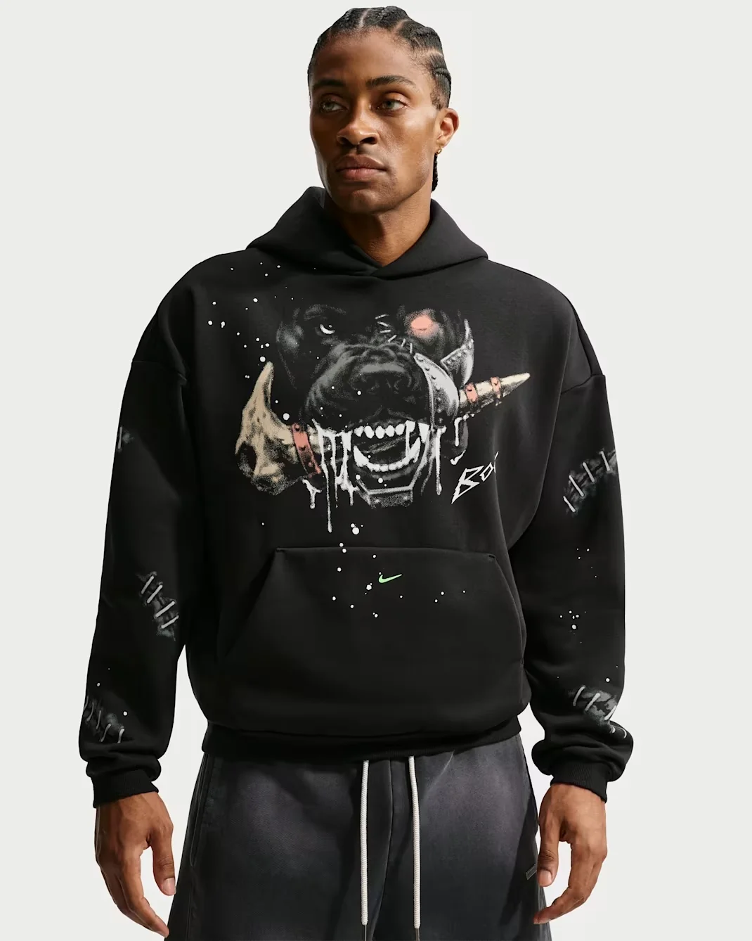 Model wearing the black Nike Book Standard Issue Halloween hoodie with a large snarling dog graphic, stitched sleeve details and green Nike Swoosh.